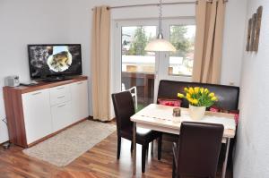 ein Esszimmer mit einem Tisch mit Stühlen und einem TV in der Unterkunft Appartment Haus Birgit in Seefeld in Tirol