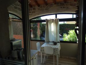 a table and chairs in a kitchen with a window at Les arbousiers in La Cadière-dʼAzur