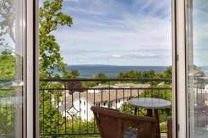 a room with a view of the ocean from a balcony at Vju Hotel Rügen in Göhren