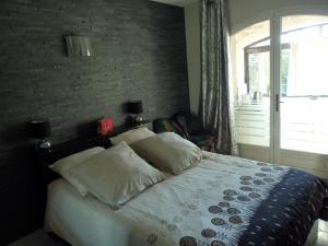 een slaapkamer met een bed met een bakstenen muur bij Les arbousiers in La Cadière-dʼAzur