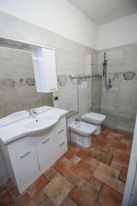 W łazience znajduje się umywalka, toaleta i prysznic. w obiekcie Il Lentischio w mieście Cala Sapone