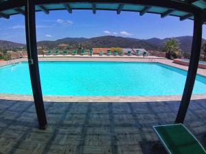 une grande piscine avec des montagnes en arrière-plan dans l'établissement Al Barcoco, à Marina di Campo