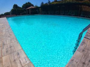 una gran piscina azul con sillas. en Al Barcoco en Marina di Campo
