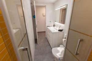 a white bathroom with a toilet and a sink at La playa a tu alcance in Salobreña