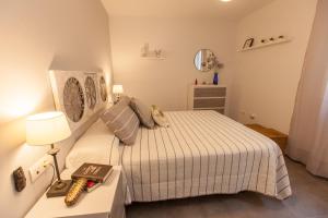 a bedroom with a bed and a table with a lamp at La playa a tu alcance in Salobreña
