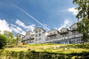a large white building on top of a hill at Vju Hotel Rügen in Göhren