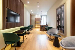 a waiting room with green chairs and tables at ELICAL Exclusive Private Suites in Rome