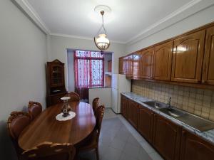 uma cozinha com uma mesa de madeira e um lavatório em Heart of Tirana em Tirana