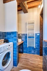 y baño de azulejos azules con lavadora. en La casina di Iole en Montepulciano