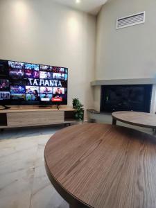 a living room with a table and a flat screen tv at Rapsani Panorama Villa in Rapsáni +82 photos