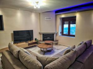 a living room with a couch and a flat screen tv at Rapsani Panorama Villa in Rapsáni