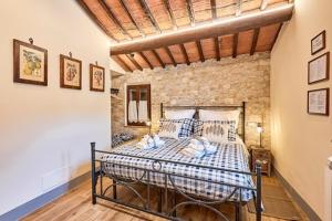 1 dormitorio con 1 cama grande en una pared de ladrillo en La casina di Iole en Montepulciano