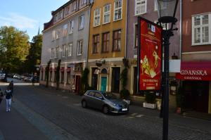 een kleine auto geparkeerd in een straat naast gebouwen bij Parlament in Gdańsk