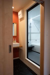 a bathroom with a shower and a sink and a mirror at HANASTAY花渓居 · 柳（YANAGI) in Osaka
