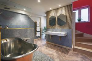 a bathroom with a tub and a sink at Ffolkes Arms Hotel in Hillington