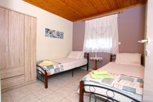 a bedroom with two beds and a window at Alexia's House in Leptokarya