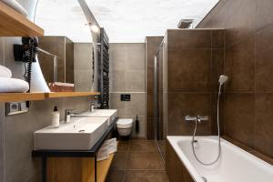 a bathroom with two sinks and a tub and a toilet at Atrium Hotel - Family friendly in Nový Smokovec