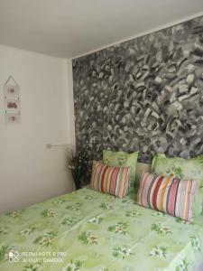 a bedroom with a bed with green sheets and pillows at Vila Calix in Băile Govora