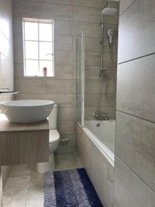 uma casa de banho com uma banheira, um WC e um lavatório. em Castle45 em Roodepoort