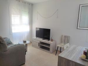 a living room with a flat screen tv and a couch at Apartament La Morra in Sant Carles de la Ràpita