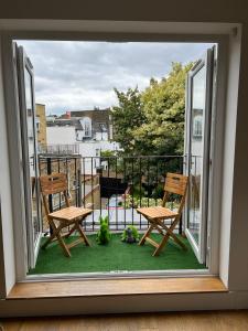 Habitación con vistas a un balcón con 2 sillas y una mesa. en Charming 2 bed apartment Free WiFi close to Camden en Londres