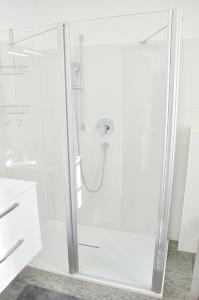 eine weiße Dusche mit Glastür im Bad in der Unterkunft Appartment Haus Birgit in Seefeld in Tirol