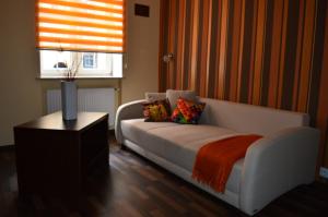 een woonkamer met een witte bank en een raam bij Parlament in Gdańsk