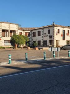 eine Straße mit einem Parkplatz vor den Gebäuden in der Unterkunft Hostal La Plata in Oropesa