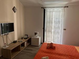 a bedroom with a bed and a tv and a window at Draga Rooms in Njivice +34 photos