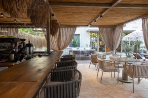 a restaurant with a bar with chairs and tables at ASHA ALAÇATI in Çeşme