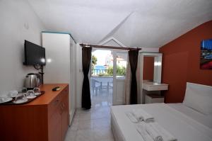 a bedroom with a bed and a desk with a television at Lale Otel in Turunç