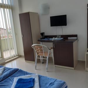 a bedroom with a desk with a chair and a tv at Green House in Eforie Sud