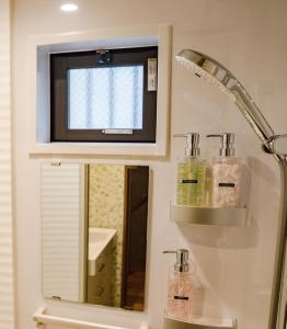 La salle de bains est pourvue d'un miroir et d'un lavabo. dans l'établissement 京 吉乃家, à Giommachi