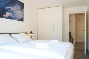 a bedroom with a white bed with white sheets at Apartment Oleander in Naturno