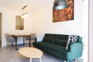 uma sala de estar com um sofá verde e uma mesa em Apartment Oleander em Naturno