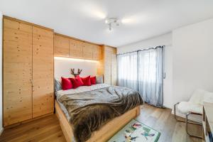 1 dormitorio con 1 cama grande con almohadas rojas en In the heart of Crans, fireplace and parking, en Crans-Montana