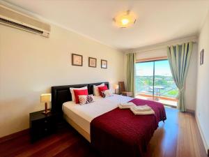 アルブフェイラにあるAlbufeira Modern 2 With Pool by Homingのベッドルーム1室(赤い枕のベッド1台、窓付) +30枚の写真