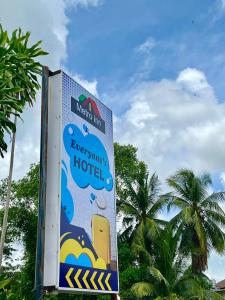 ein Schild für ein Hotel mit Palmen im Hintergrund in der Unterkunft Metroinn Hotel in Arau