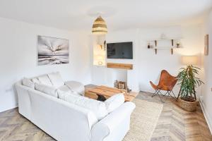 ein Wohnzimmer mit einem weißen Sofa und einem TV in der Unterkunft Host & Stay - Tally House in West Rainton