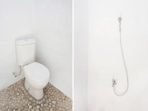 ein Bad mit einem WC und einer Dusche in der Unterkunft OYO 91544 Homestay Biru Blukid in Sidoarjo