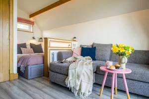 a living room with a couch and a table at Bonnie Barns - Luxury Lodges with hot tubs in Luss