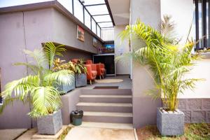 un couloir avec des escaliers et des palmiers dans un bâtiment dans l'établissement Yvanka Appart'City Antsirabe, à Antsirabe
