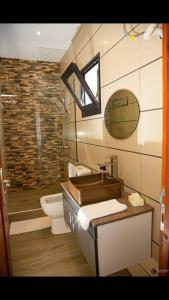 baño con lavabo y aseo y ventana en Yvanka Appart'City Antsirabe, en Antsirabe