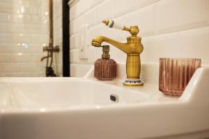 a bathroom sink with a gold faucet on it at Sylte Hotell, Valldal in Valldal
