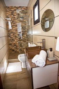 a bathroom with a sink and a toilet and a mirror at Yvanka Appart'City Antsirabe in Antsirabe