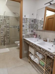 ein Bad mit einem Waschbecken, einer Dusche und einem WC in der Unterkunft Casa Vacanze Il Giardino Dei Girasoli in Marina di Ragusa