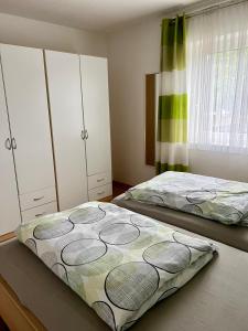 GuggenbergにあるFerienwohnung am Mattseeのベッドルーム1室(ベッド2台、キャビネット、窓付)