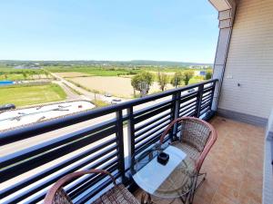 a balcony with two chairs and a table at Warm & Cozy Inn in Hengchun South Gate