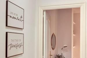 a hallway with two pictures on the wall and a mirror at Quiet Marina Gardens Apartment in A Coruña