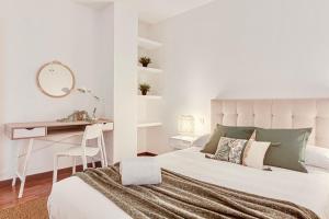 a white bedroom with a bed and a desk at Quiet Marina Gardens Apartment in A Coruña